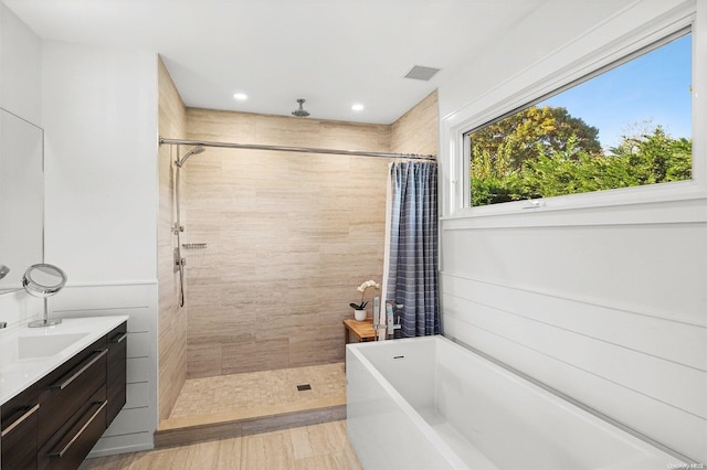 bathroom featuring plus walk in shower, hardwood / wood-style floors, and vanity