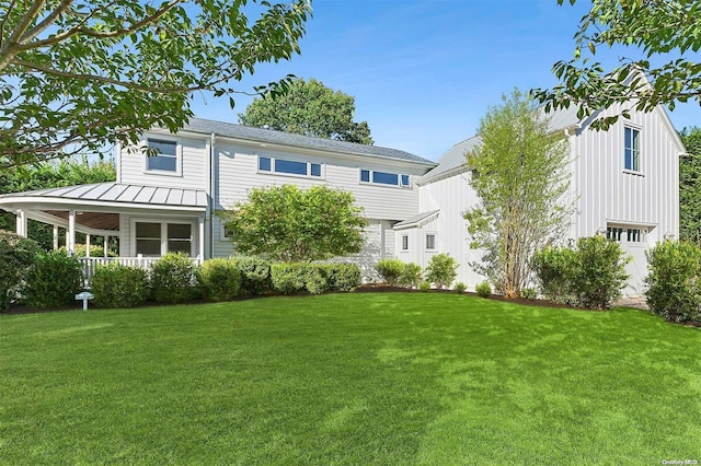 rear view of property with a lawn and a porch