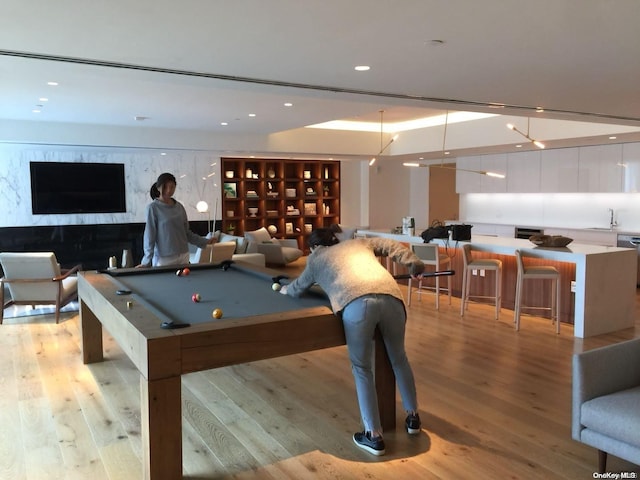 game room with sink, light hardwood / wood-style floors, and billiards