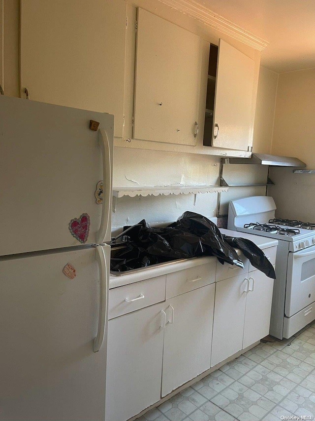 kitchen featuring white cabinets and white appliances