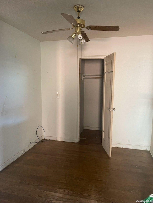 unfurnished bedroom featuring a closet, dark hardwood / wood-style floors, and ceiling fan