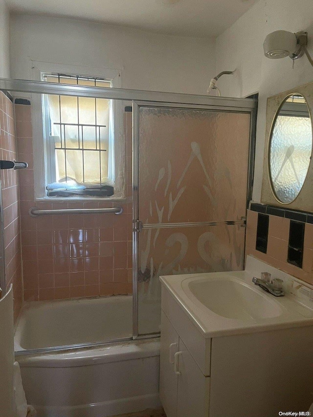 bathroom featuring backsplash, vanity, and enclosed tub / shower combo