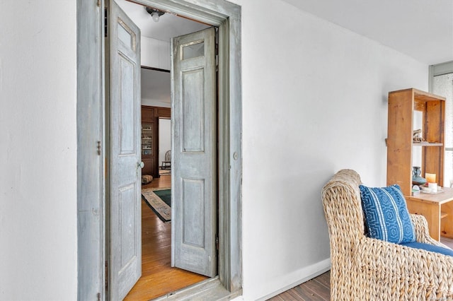 corridor with hardwood / wood-style flooring