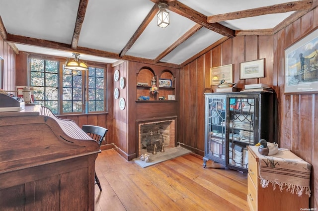 office with vaulted ceiling with beams, wooden walls, and light wood-type flooring