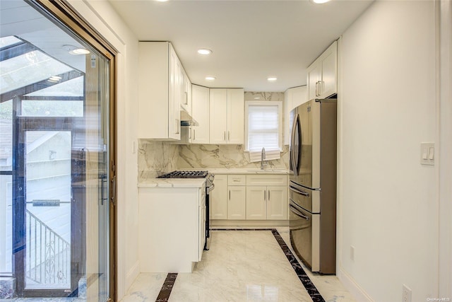 kitchen with tasteful backsplash, stainless steel refrigerator, white cabinetry, and white range with gas cooktop