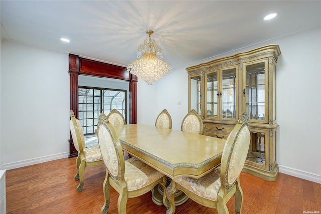 dining space featuring hardwood / wood-style floors and an inviting chandelier