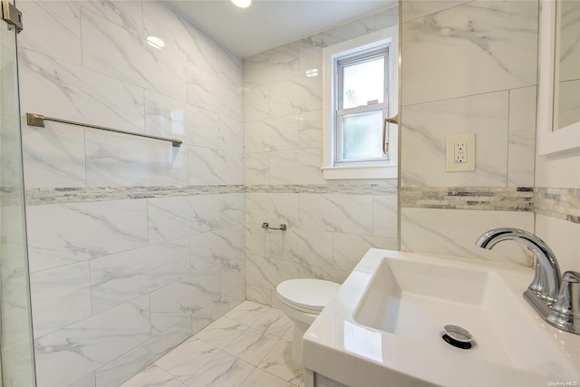 bathroom with vanity, toilet, and tile walls