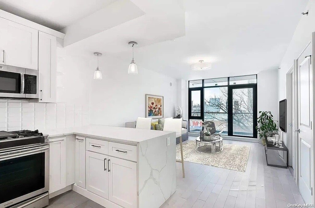 41-04 27th St Unit 4A, Long Island City, NY 11101 - kitchen with stainless steel appliances, open floor plan, tasteful backsplash, a peninsula, and white cabinets