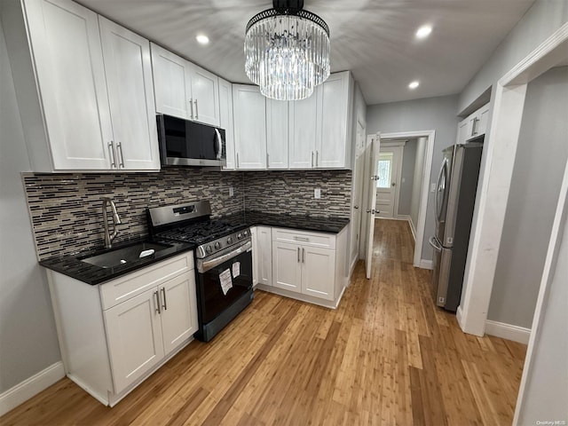 kitchen featuring appliances with stainless steel finishes, white cabinetry, and sink