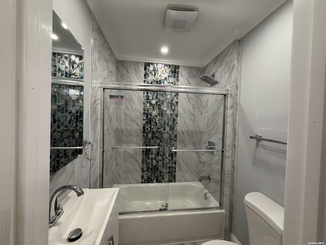 full bathroom featuring crown molding, vanity, combined bath / shower with glass door, and toilet