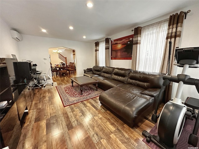 living room with a wall mounted AC and wood-type flooring