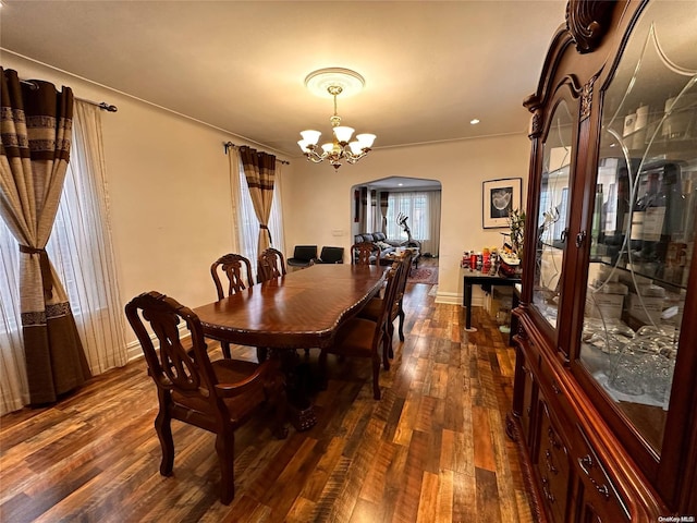 dining room with a wealth of natural light, dark wood-type flooring, and a notable chandelier