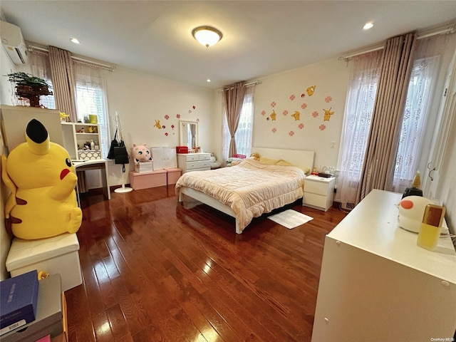 bedroom featuring hardwood / wood-style floors, multiple windows, and a wall mounted AC