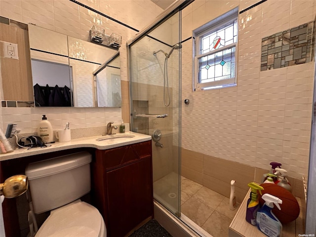 bathroom featuring tasteful backsplash, a shower with door, vanity, and tile walls