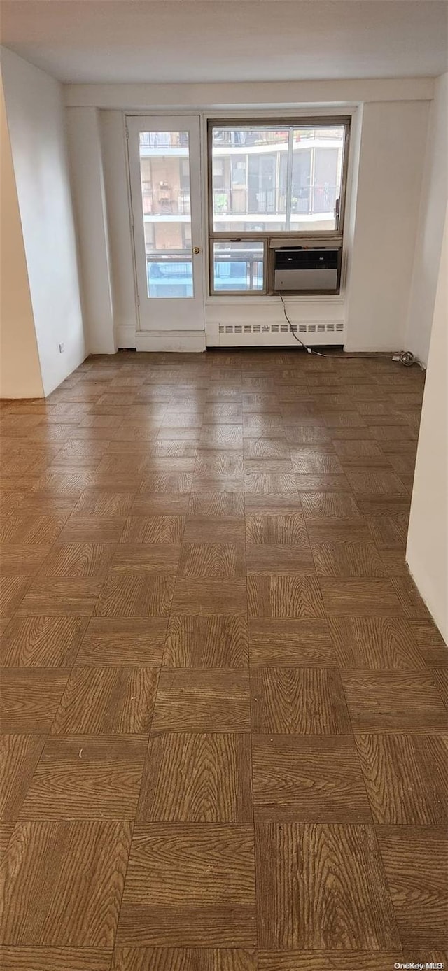 empty room with a baseboard radiator and a wall mounted air conditioner