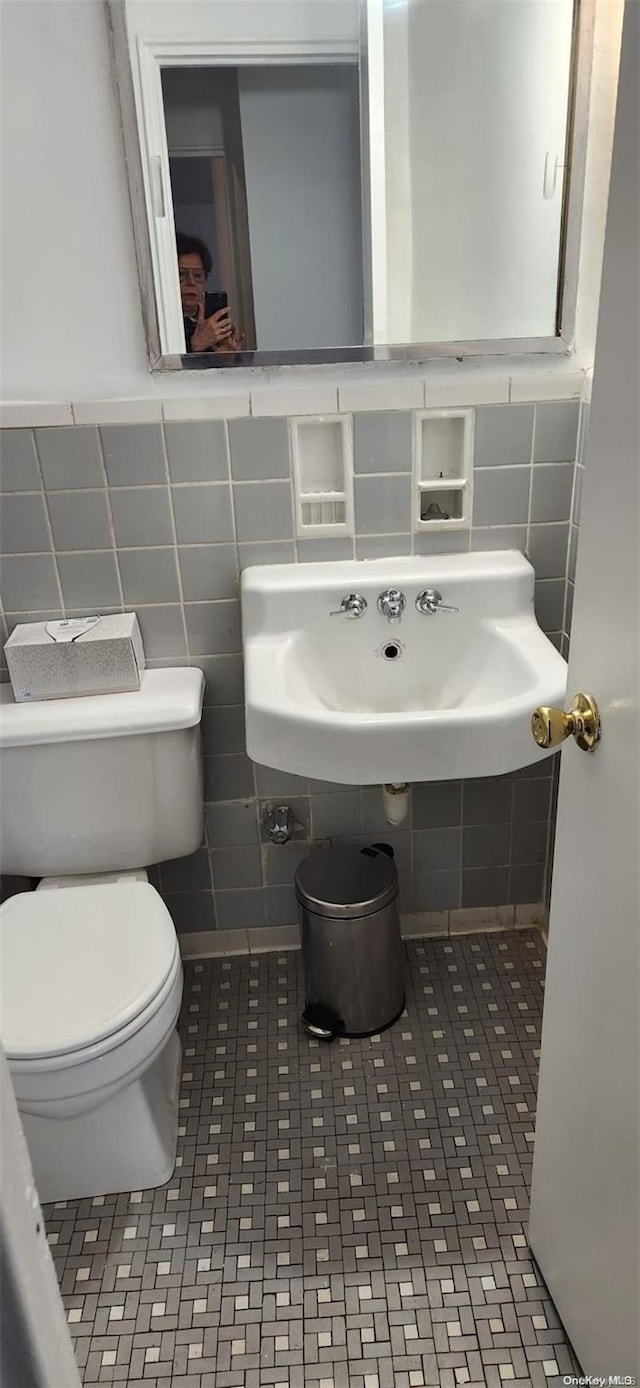 bathroom with tile walls and toilet