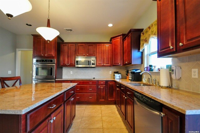 kitchen with light stone counters, stainless steel appliances, sink, pendant lighting, and light tile patterned flooring