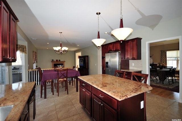 kitchen with stainless steel fridge with ice dispenser, a center island, plenty of natural light, and light wood-type flooring