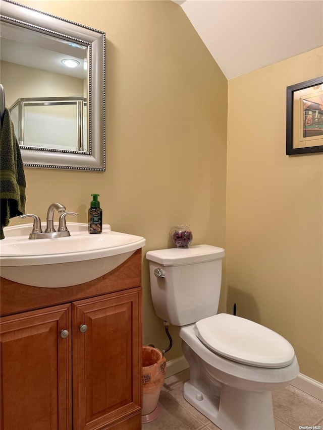 bathroom with tile patterned floors, vanity, vaulted ceiling, and toilet