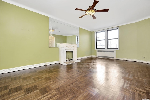 unfurnished living room featuring ceiling fan, dark parquet flooring, and radiator