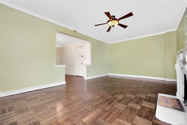 unfurnished living room featuring ceiling fan with notable chandelier, dark parquet flooring, and ornamental molding