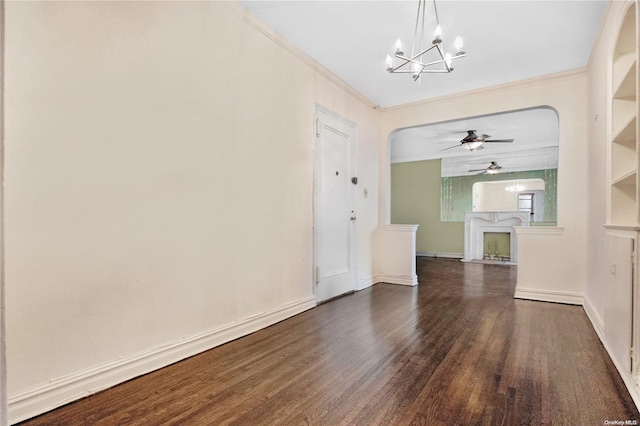 interior space with ceiling fan with notable chandelier, dark hardwood / wood-style floors, and ornamental molding