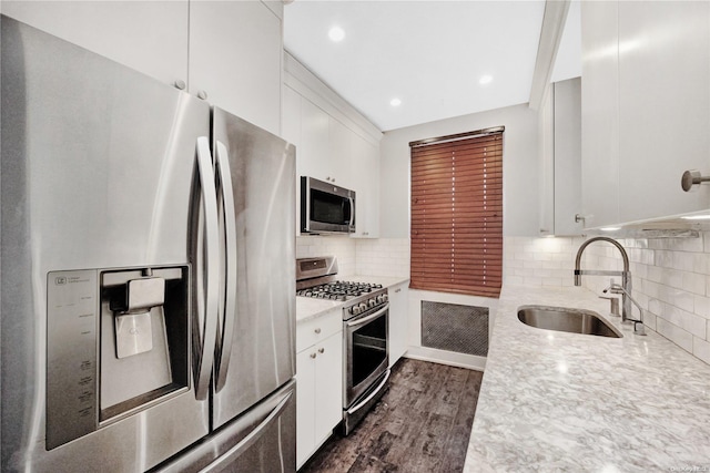 kitchen with dark hardwood / wood-style floors, sink, white cabinetry, and stainless steel appliances