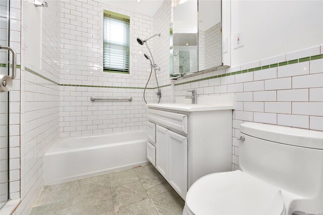 full bathroom featuring tile patterned floors, toilet, vanity, tile walls, and tiled shower / bath