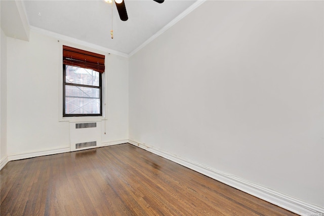 spare room featuring radiator, ceiling fan, dark wood-type flooring, and ornamental molding