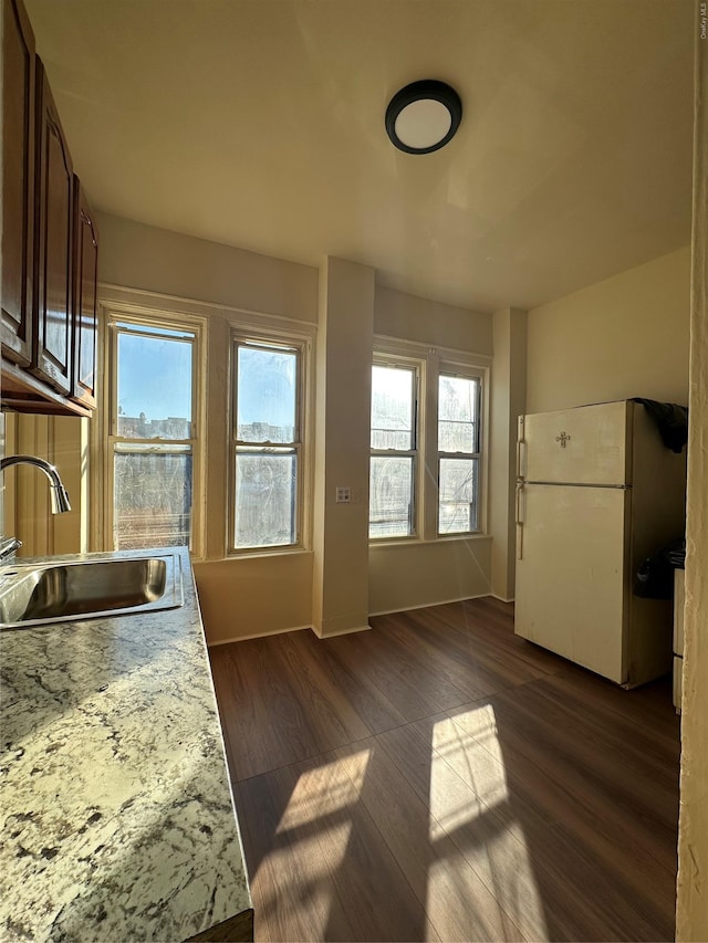 kitchen with sink, white fridge, and dark wood-type flooring