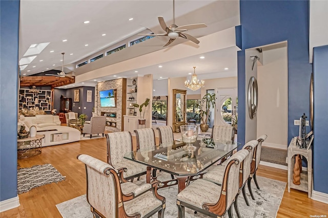 dining area with ceiling fan with notable chandelier and light hardwood / wood-style flooring