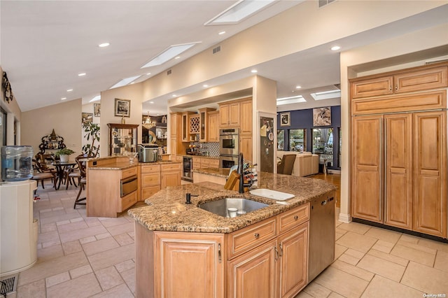 kitchen featuring sink, light stone countertops, a large island, a breakfast bar area, and stainless steel appliances