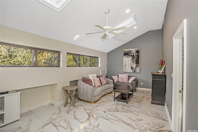 living area featuring ceiling fan and vaulted ceiling with skylight