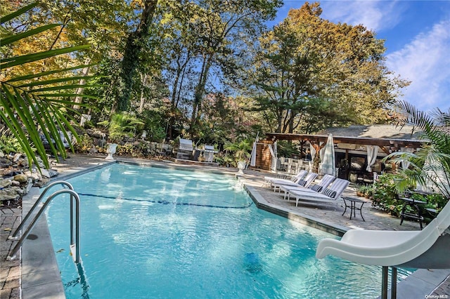 view of pool featuring a patio and a water slide