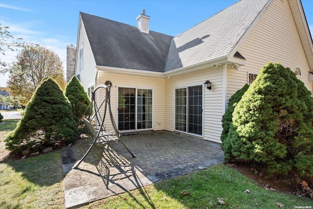 rear view of house with a patio area and a lawn