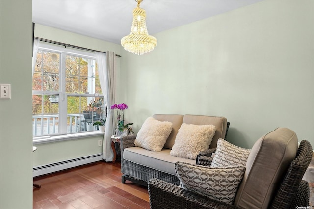 sitting room with wood-type flooring, baseboard heating, and a chandelier