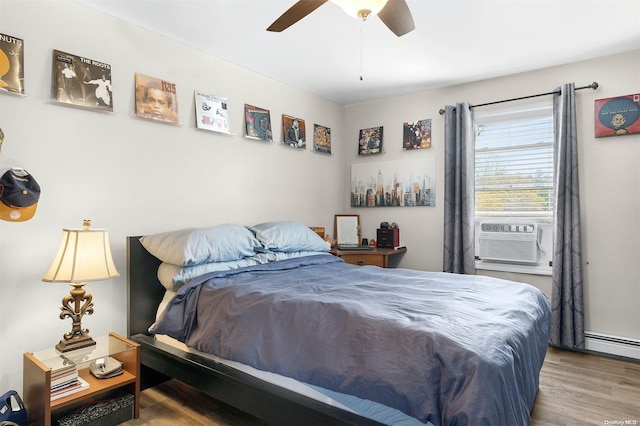 bedroom featuring a baseboard heating unit, hardwood / wood-style flooring, ceiling fan, and cooling unit