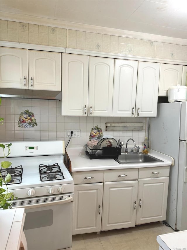 kitchen with white appliances, white cabinets, sink, decorative backsplash, and light tile patterned floors