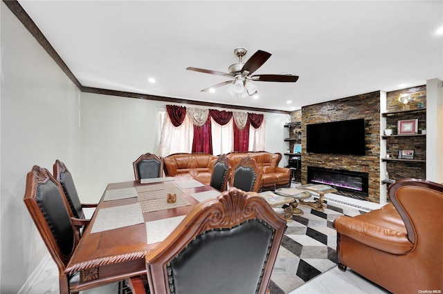 living room with ceiling fan, crown molding, and a fireplace