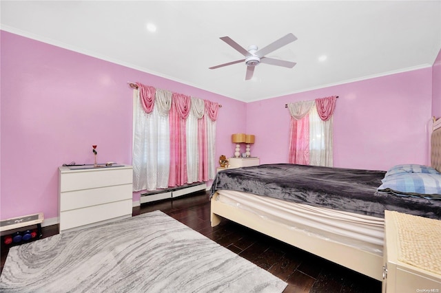 bedroom with ceiling fan, crown molding, dark wood-type flooring, and a baseboard heating unit