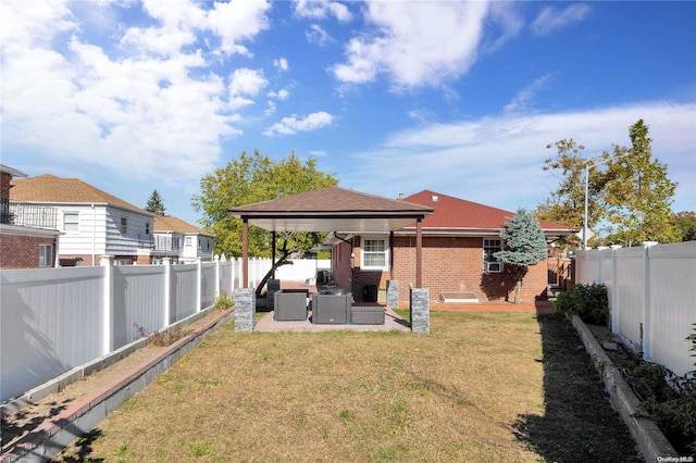 rear view of property with a gazebo, outdoor lounge area, and a lawn