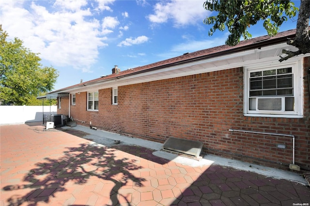 back of house with central air condition unit and a patio