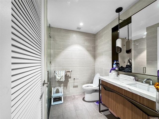 bathroom featuring vanity, toilet, tile walls, and walk in shower