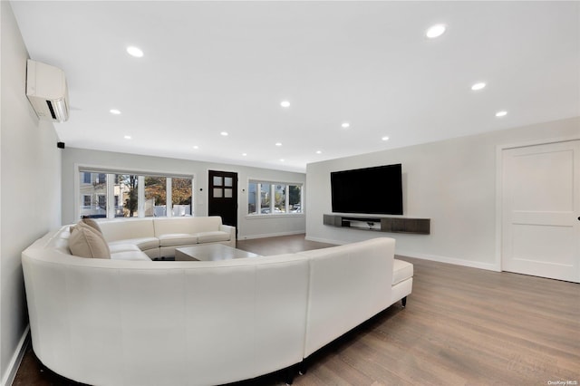 living room featuring a wall mounted air conditioner and wood-type flooring