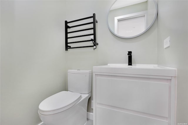 bathroom featuring vanity, toilet, and radiator