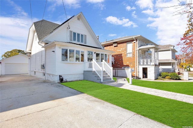 view of front of property featuring an outbuilding, a garage, and a front yard