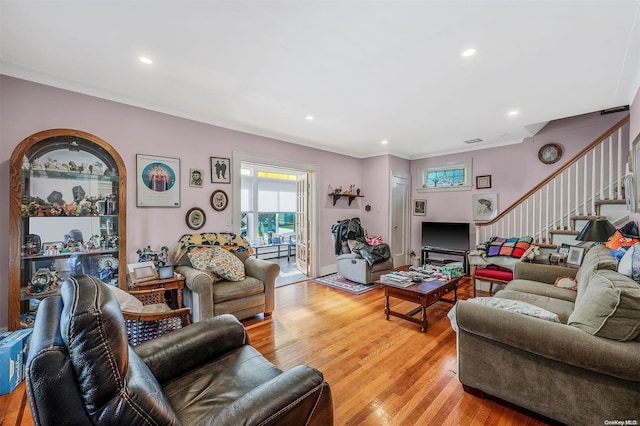 living room with light hardwood / wood-style flooring and ornamental molding