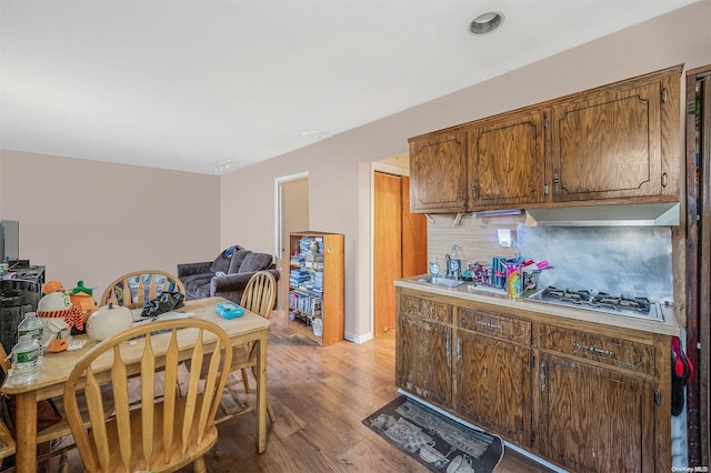 kitchen with sink, stainless steel gas cooktop, and light hardwood / wood-style flooring