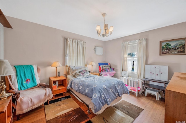 bedroom featuring a chandelier and wood-type flooring