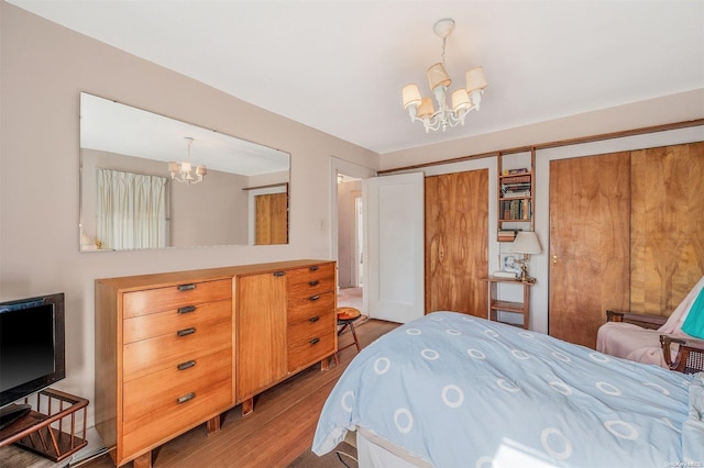 bedroom with hardwood / wood-style floors, a closet, and a notable chandelier